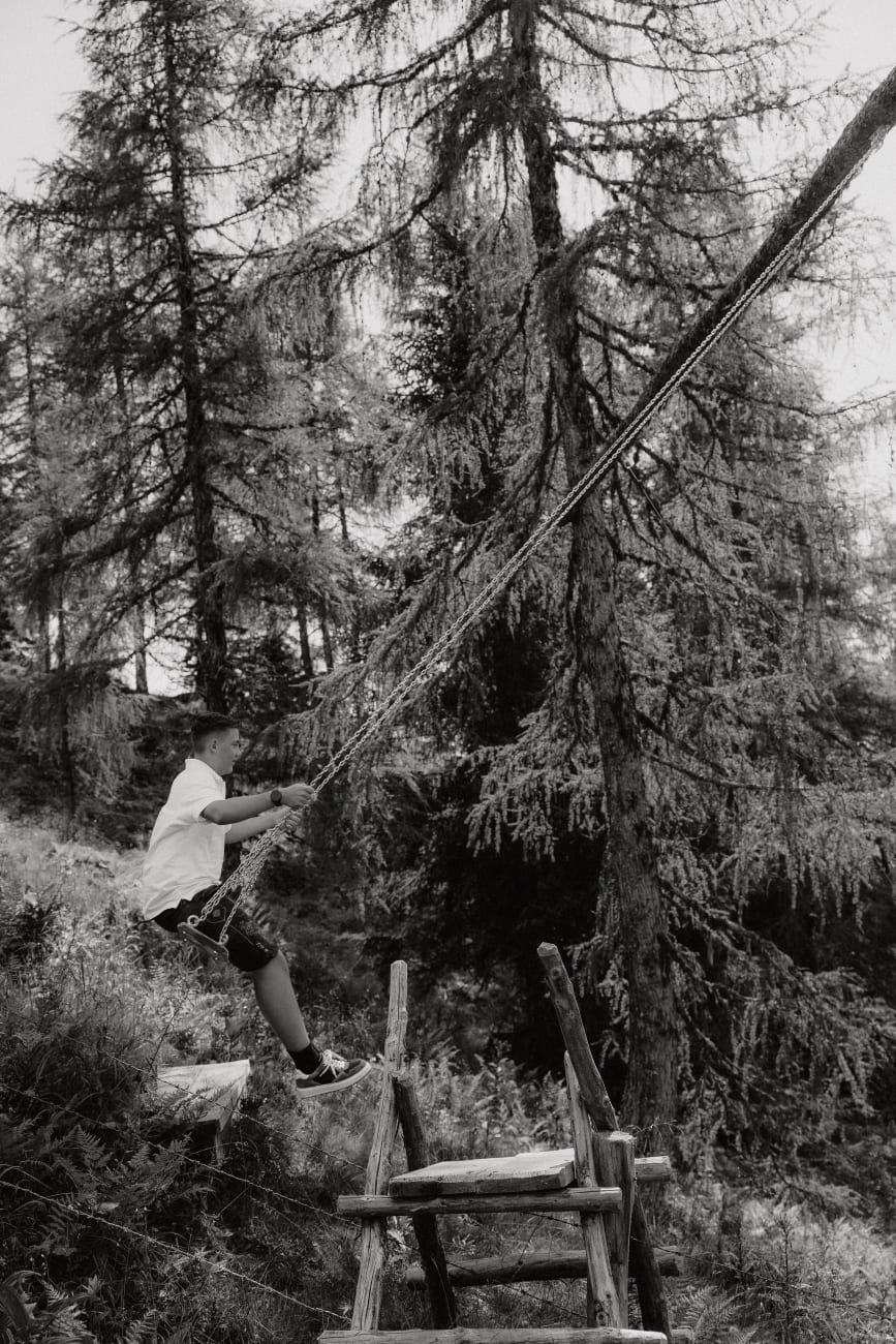 Kind schaukelt im Wald vom Großarl