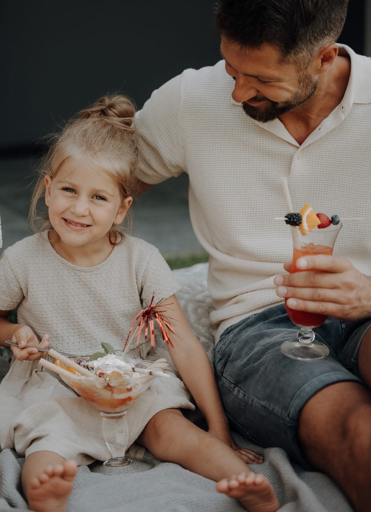 Vater und Kind beim Eis essen auf der Liegewiese