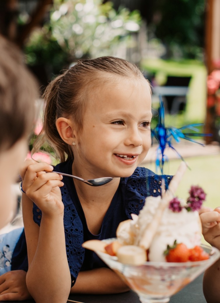 Kind genießt Eis auf der Terrasse