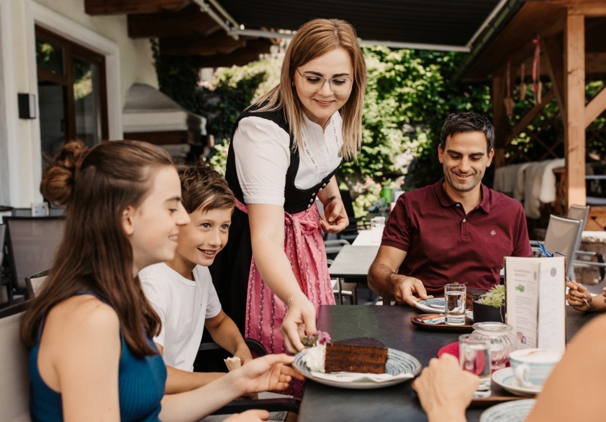Familie genießt Schokoladenkuchen auf der Terrasse