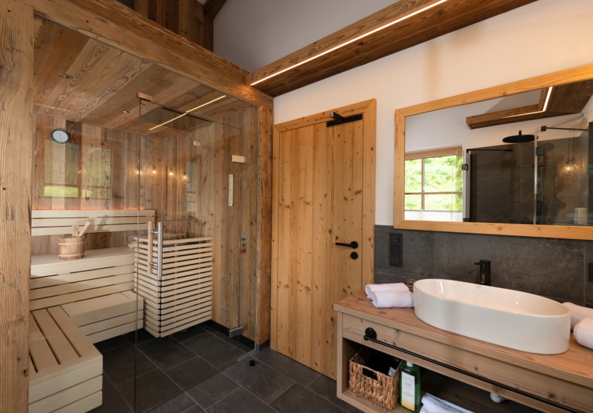Moderne Sauna und Badezimmer mit Holzverkleidung und großem Spiegel