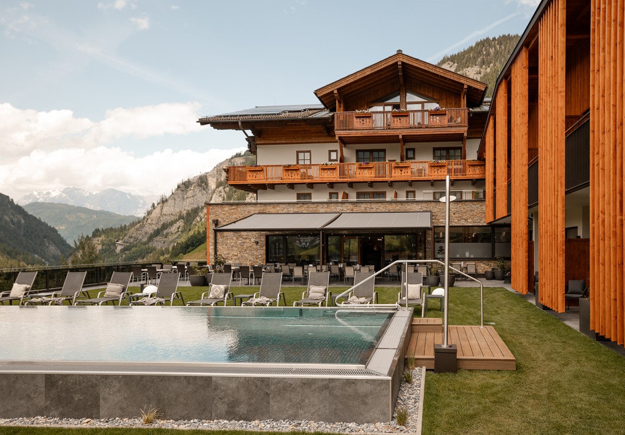 Ein modernes Hotel mit Holzdetails und Pool in einer malerischen Berglandschaft