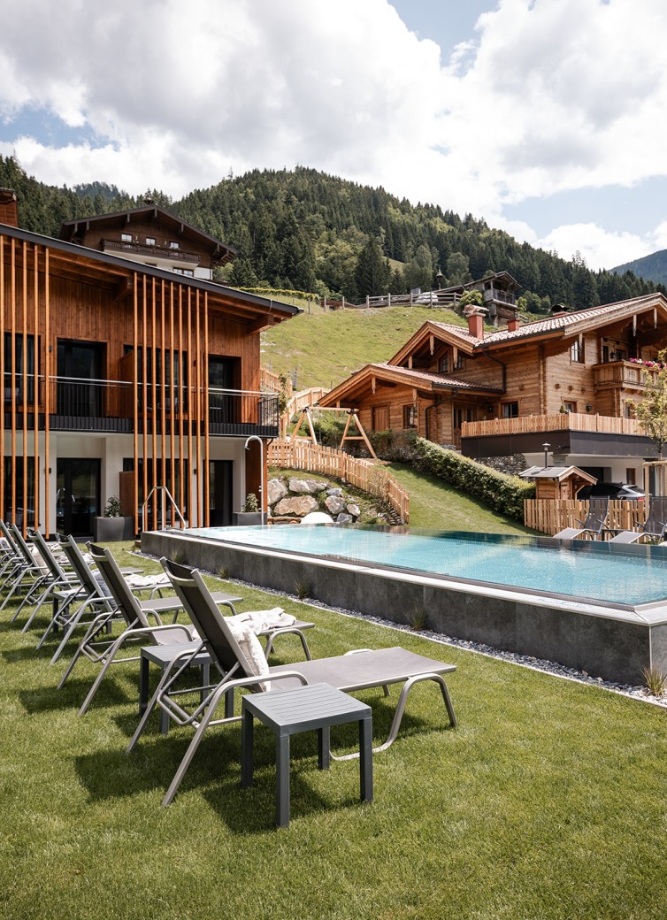 Liegestühle und ein Infinity-Pool vom Hotel Dorfer