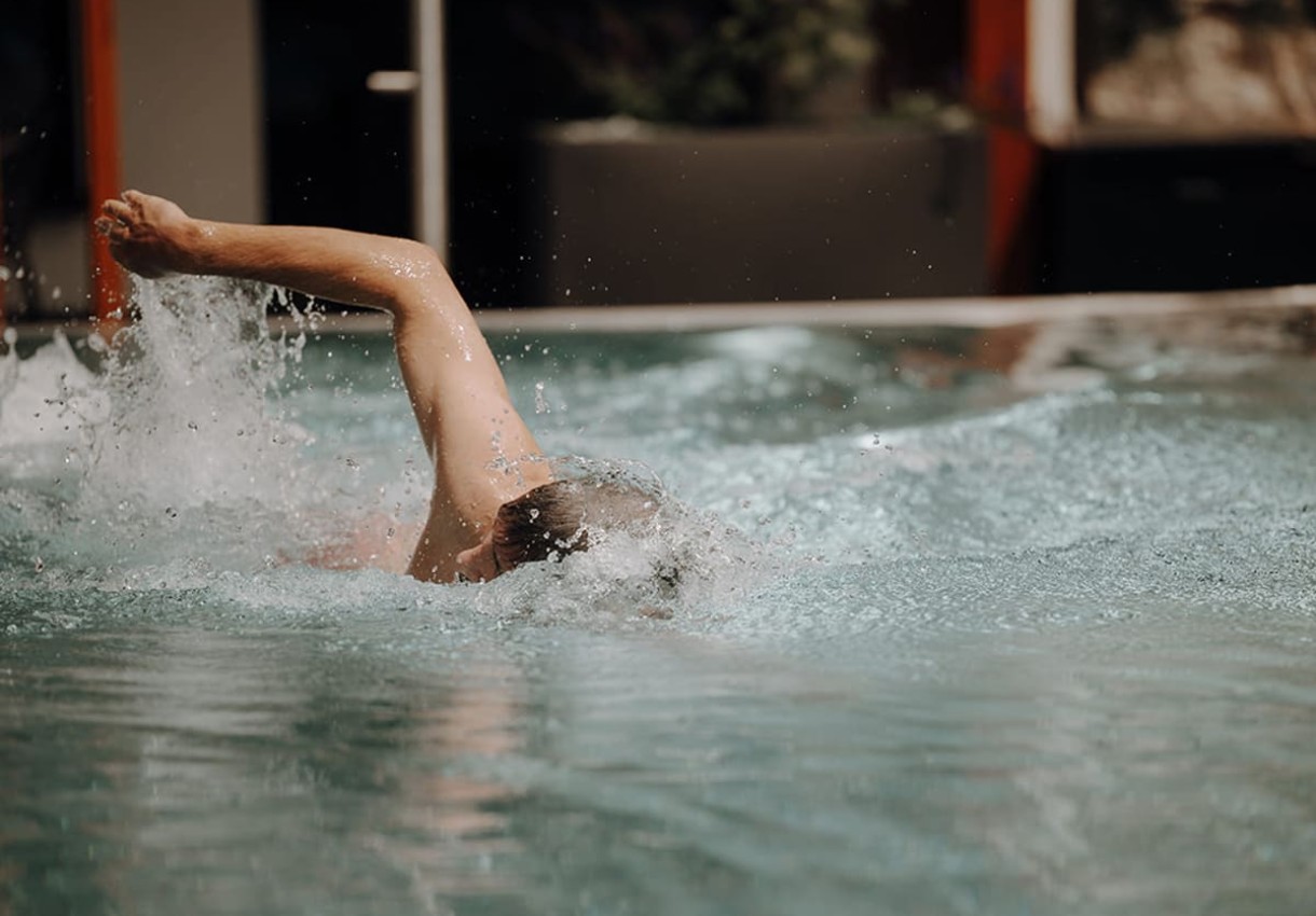 Mann schwimmt sportlich im Pool 