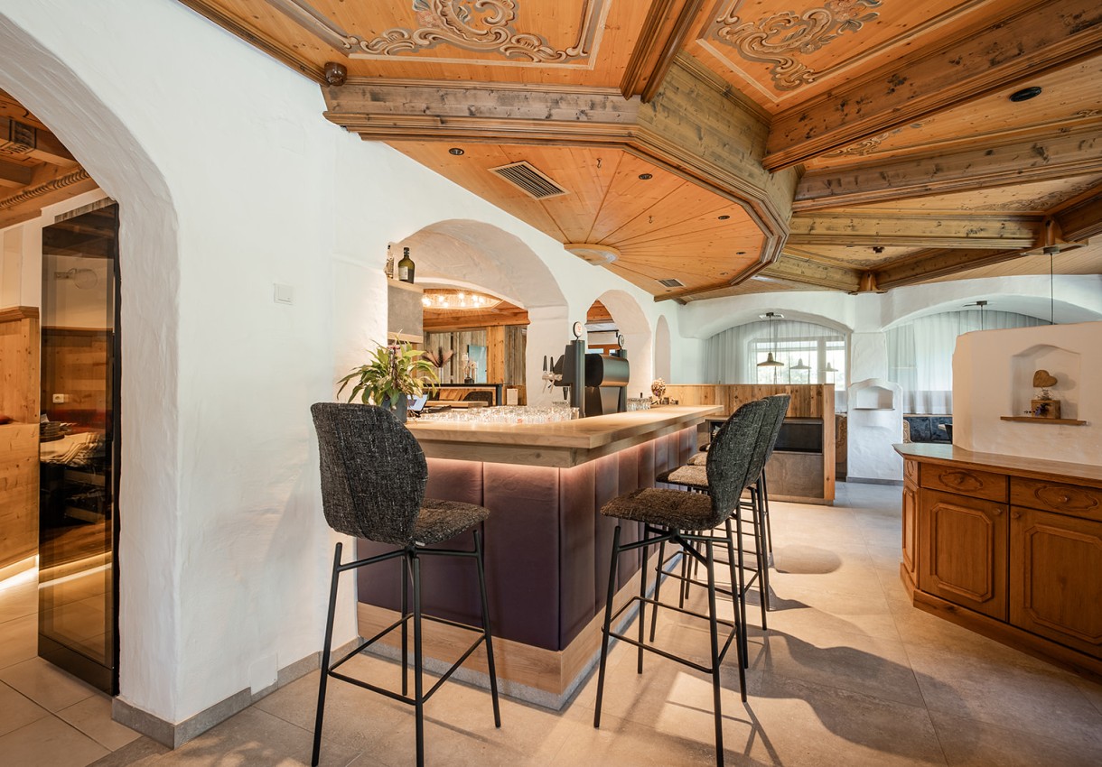 Ein gemütlicher Barbereich mit hölzerner Decke und hohen Stühlen