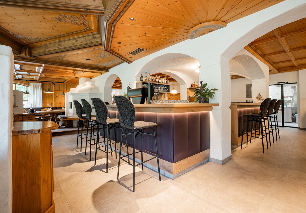 Gemütliche Bar mit Holztresen und hohen Stühlen in einer eleganten, traditionellen Einrichtung