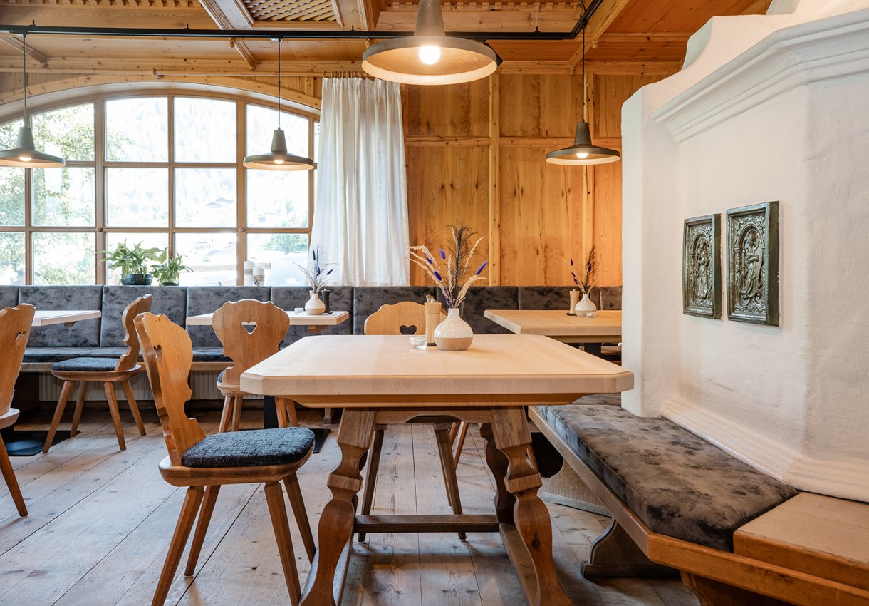 Gemütliches Restaurant mit Holzeinrichtung, großen Fenstern und dekorierten Tischen