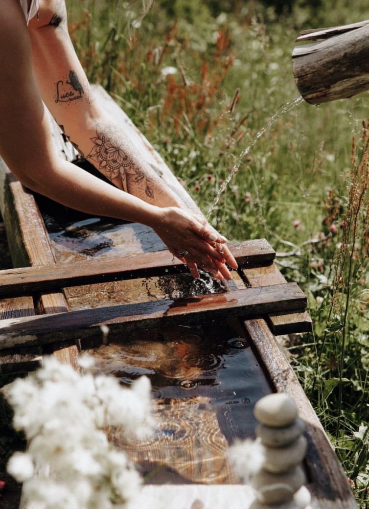 Erfrischung im Brunnen in den Bergen von Großarl
