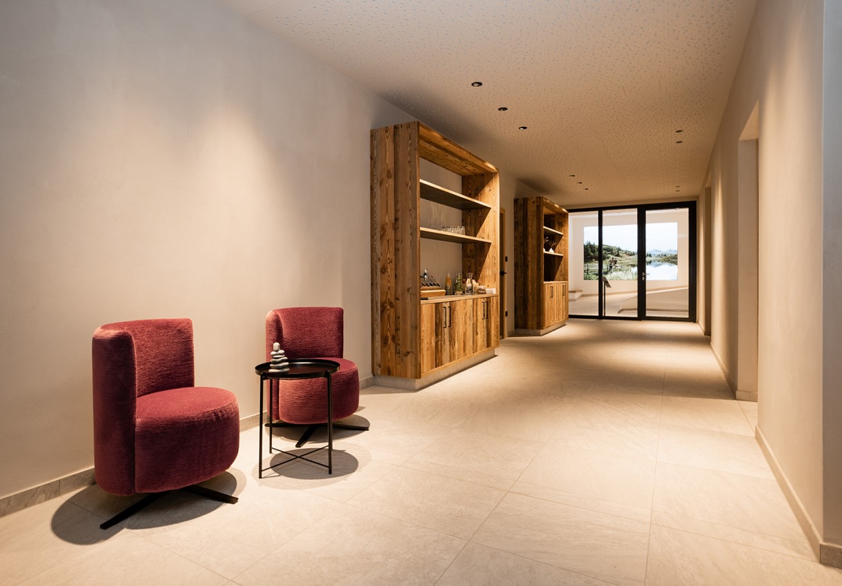 Moderner Flur mit Holzmöbeln und zwei roten Sesseln neben einem kleinen Tisch