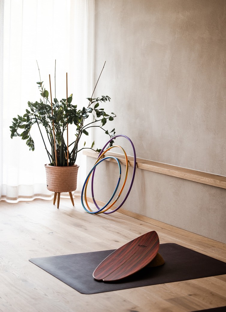 Wellnessbereich mit Pflanze, Hula-Hoops und einem Balance-Board auf einer Matte
