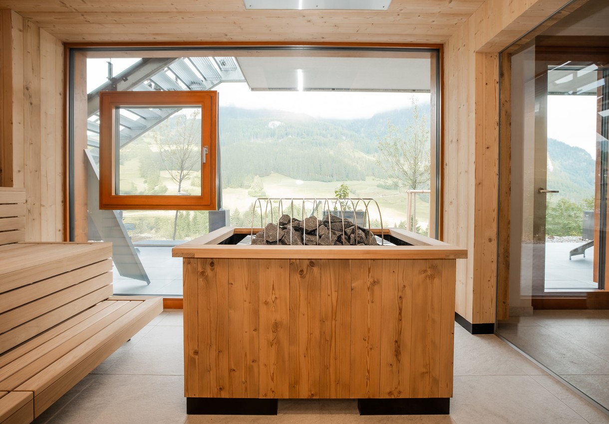 Ein Saunaofen in einem modernen Raum mit Ausblick auf eine bewaldete Landschaft