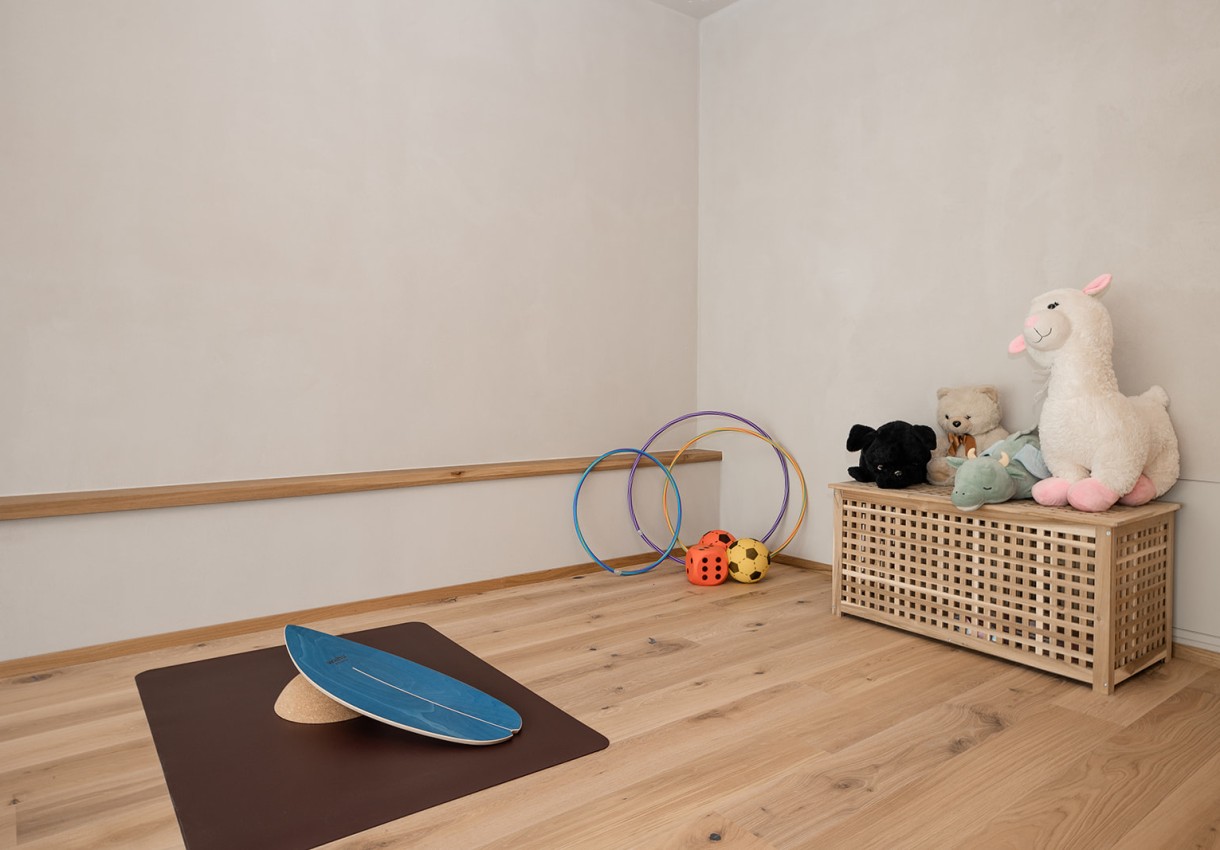  Wellnessbereich mit Spielzeug, Hula-Hoop-Reifen und Balanceboard auf Holzboden