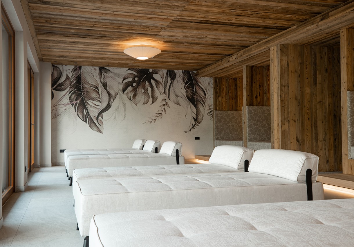 Entspannungsraum mit weißen Liegen und holzgetäfelten Wänden