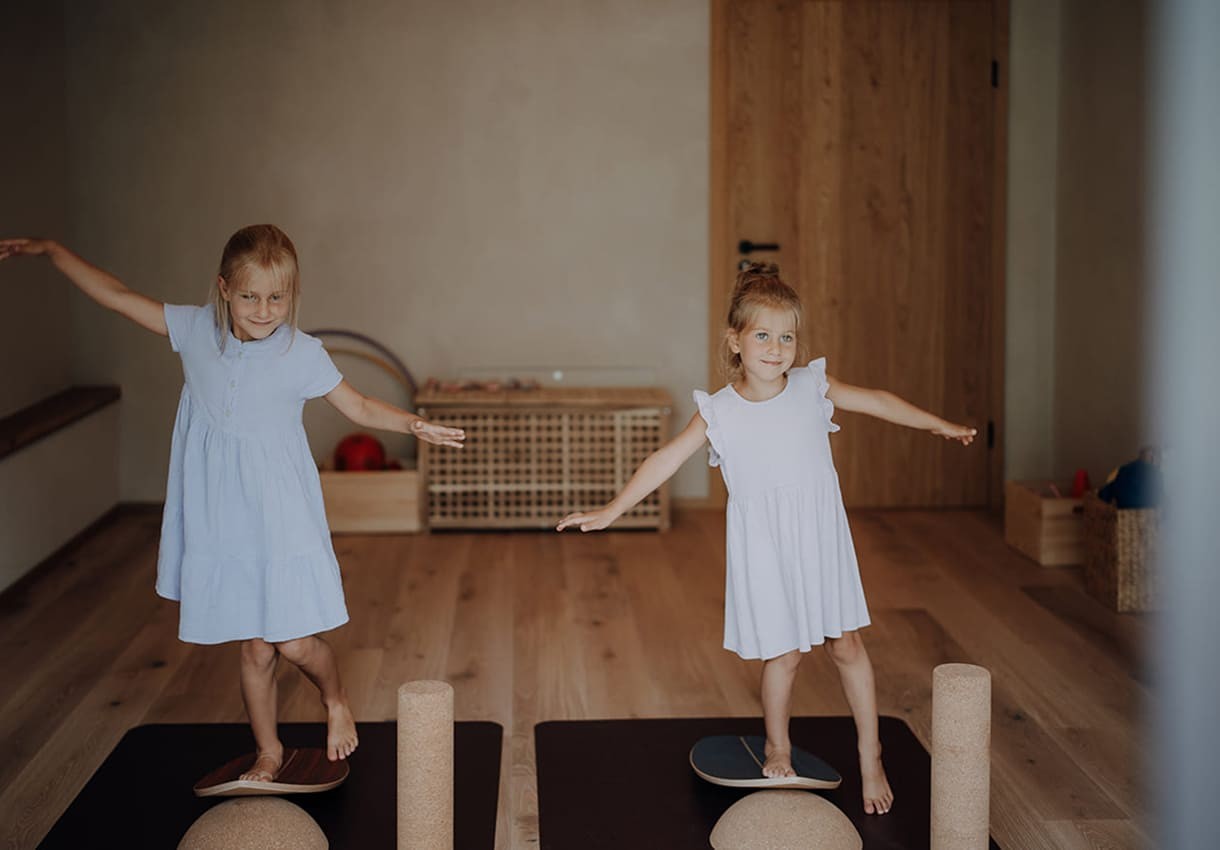 Zwei M&auml;dchen balancieren auf Gleichgewichtsboards in unserem Bewegungsraum