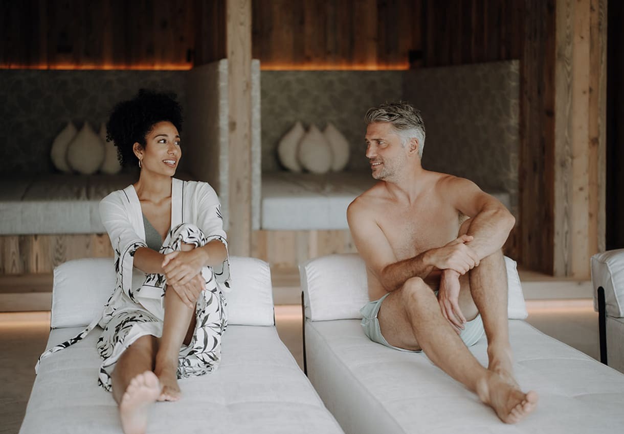 Ein Mann und eine Frau entspannen auf wei&szlig;en Liegen und unterhalten sich