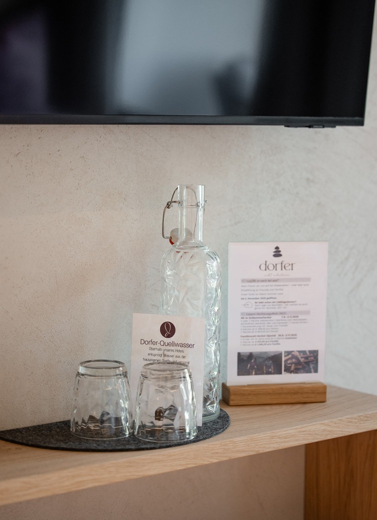 Wasserkaraffe und zwei Gläser stehen auf einem Regal neben einer Infokarte