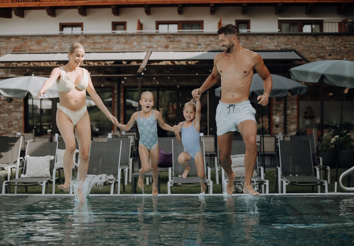 Familie springt gemeinsam in einen Pool