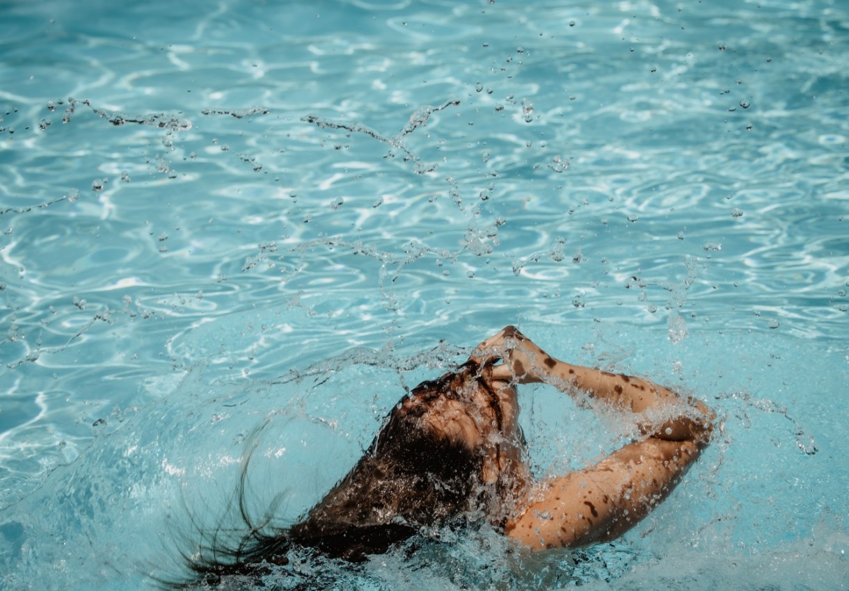 Person taucht im blauen Wasser auf