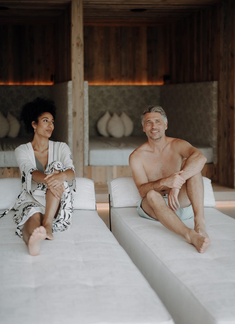 Paar entspannt auf Relaxliegen im stilvollen Ruheraum des Hotel Dorfer