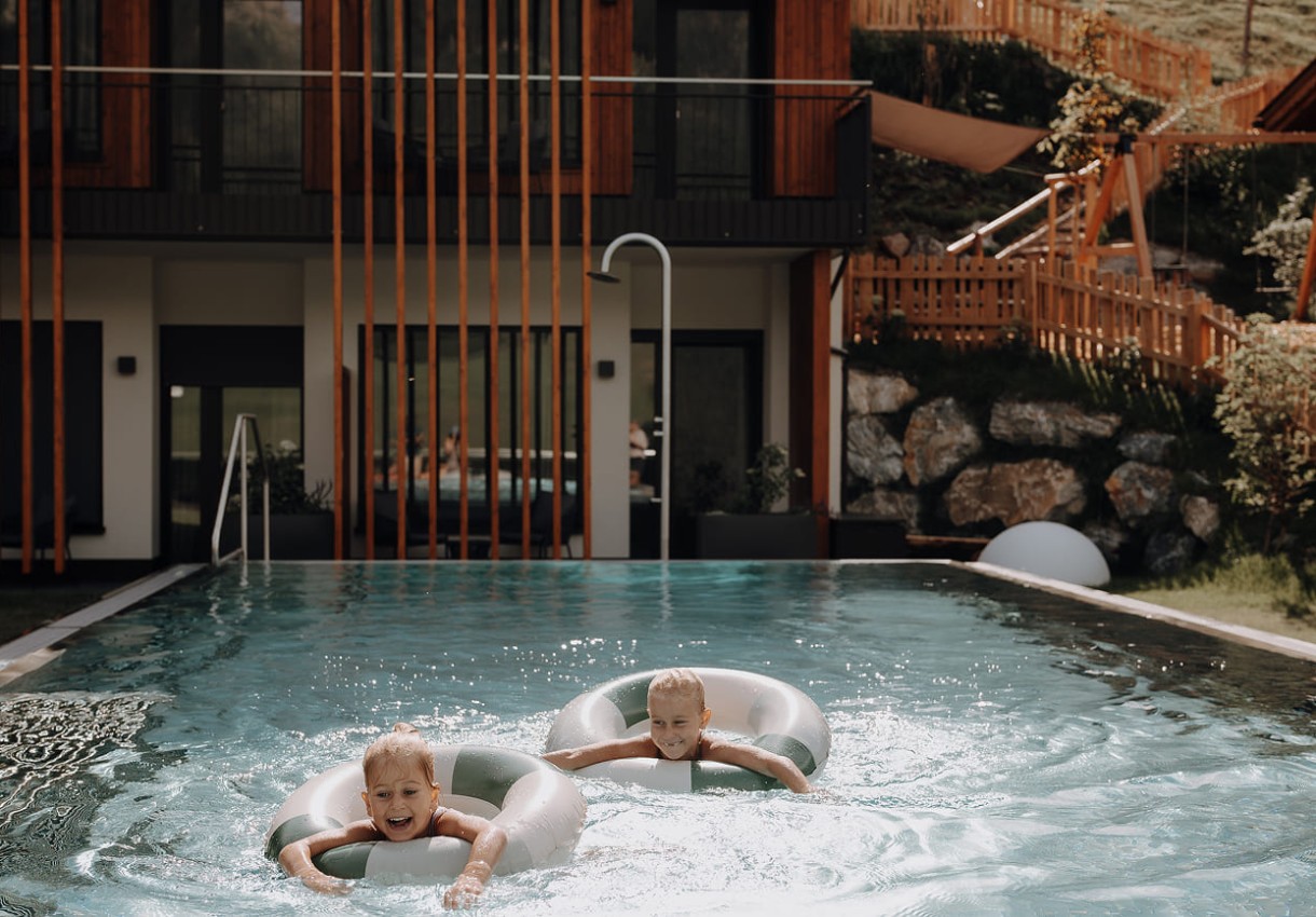 Mädchen haben Spaß beim Schwimmen mit Reifen im Dorfer-Pool