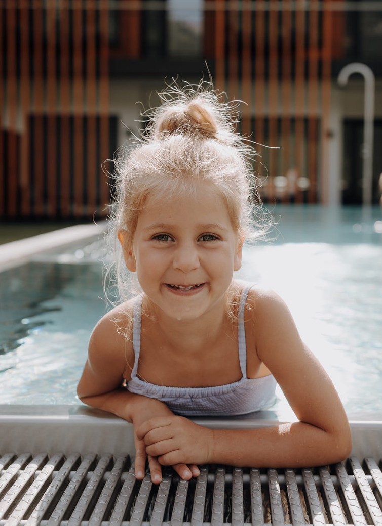 Lächelndes Mädchen beim Plantschen im Pool