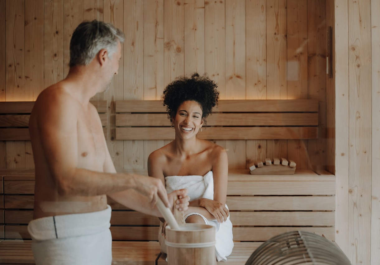 Zwei Personen entspannen sich in einer hölzernen Sauna