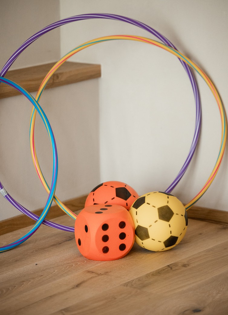 Bunte Hula-Hoop-Reifen und Spielwürfel im Bewegungsraum des Hotel Dorfer