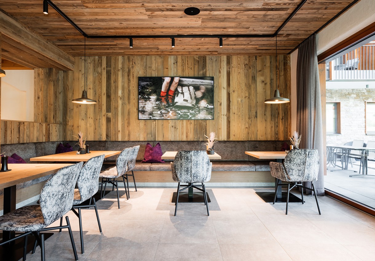 Cheers & Bites mit Holzwänden, modernen Stühlen und großen Fenstern