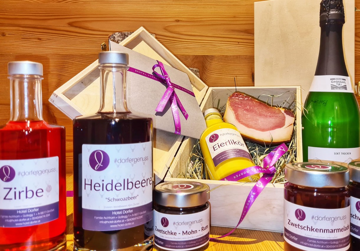 Verschiedene Genussprodukte wie Liköre, Marmeladen und Aufschnitt in einer Geschenkbox