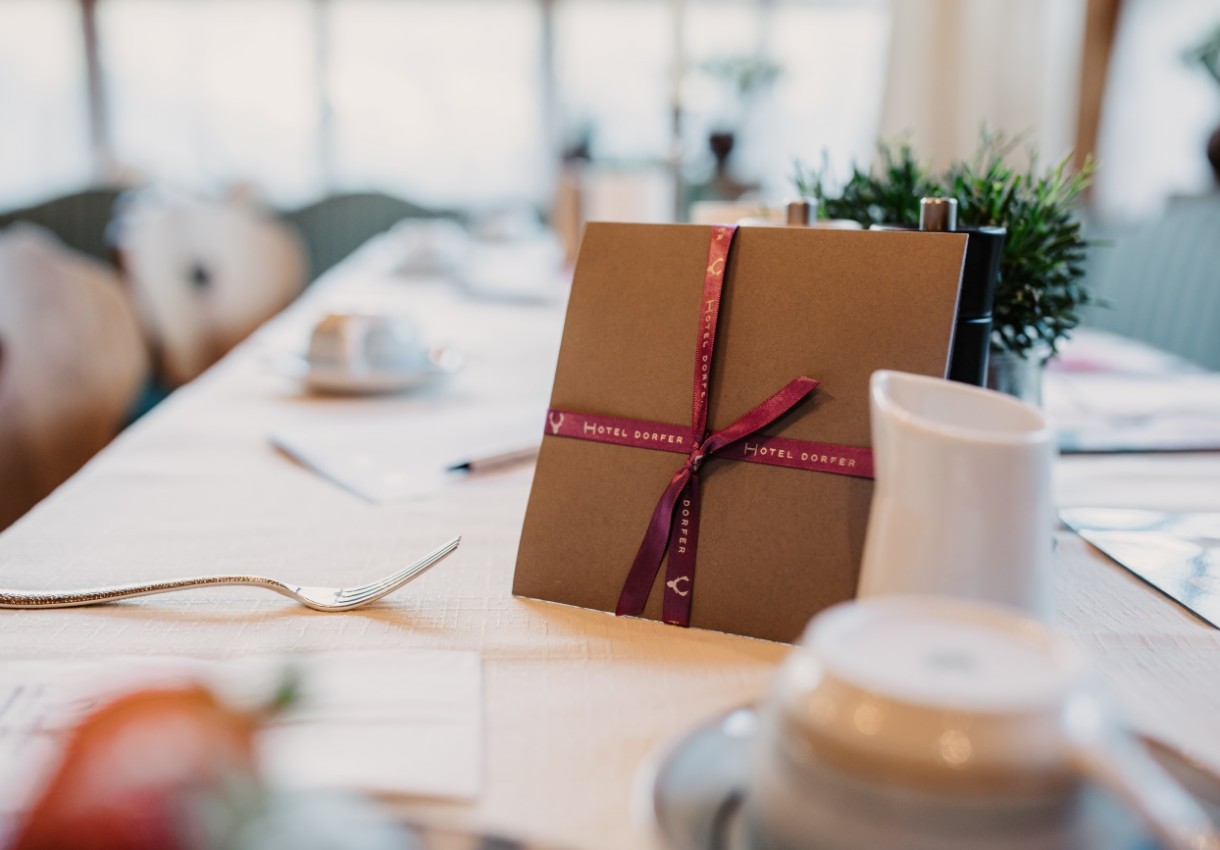 Ein dekoratives Paket liegt auf einem gedeckten Tisch in einem Café oder Restaurant