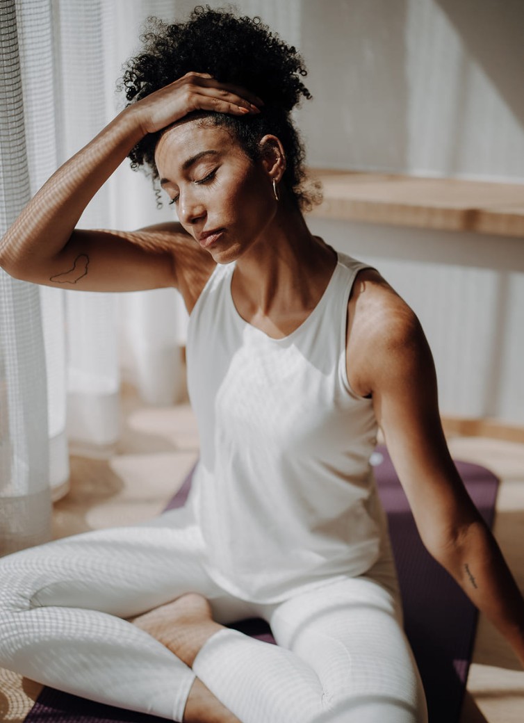 Frau meditiert auf einer Yogamatte im Dorfer-Bewegungsraum