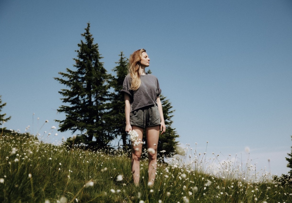 Frau genießt ihren Sommerurlaub auf einer Almwiese in Großarl