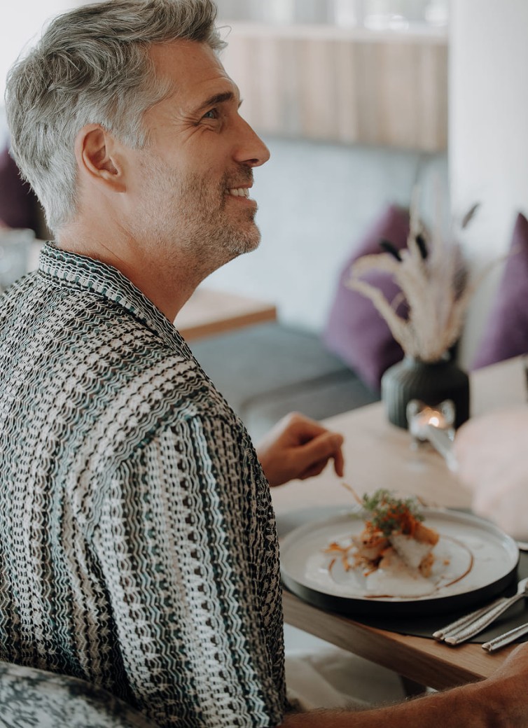 Mann lächelt beim Dinner im Hotel Dorfer