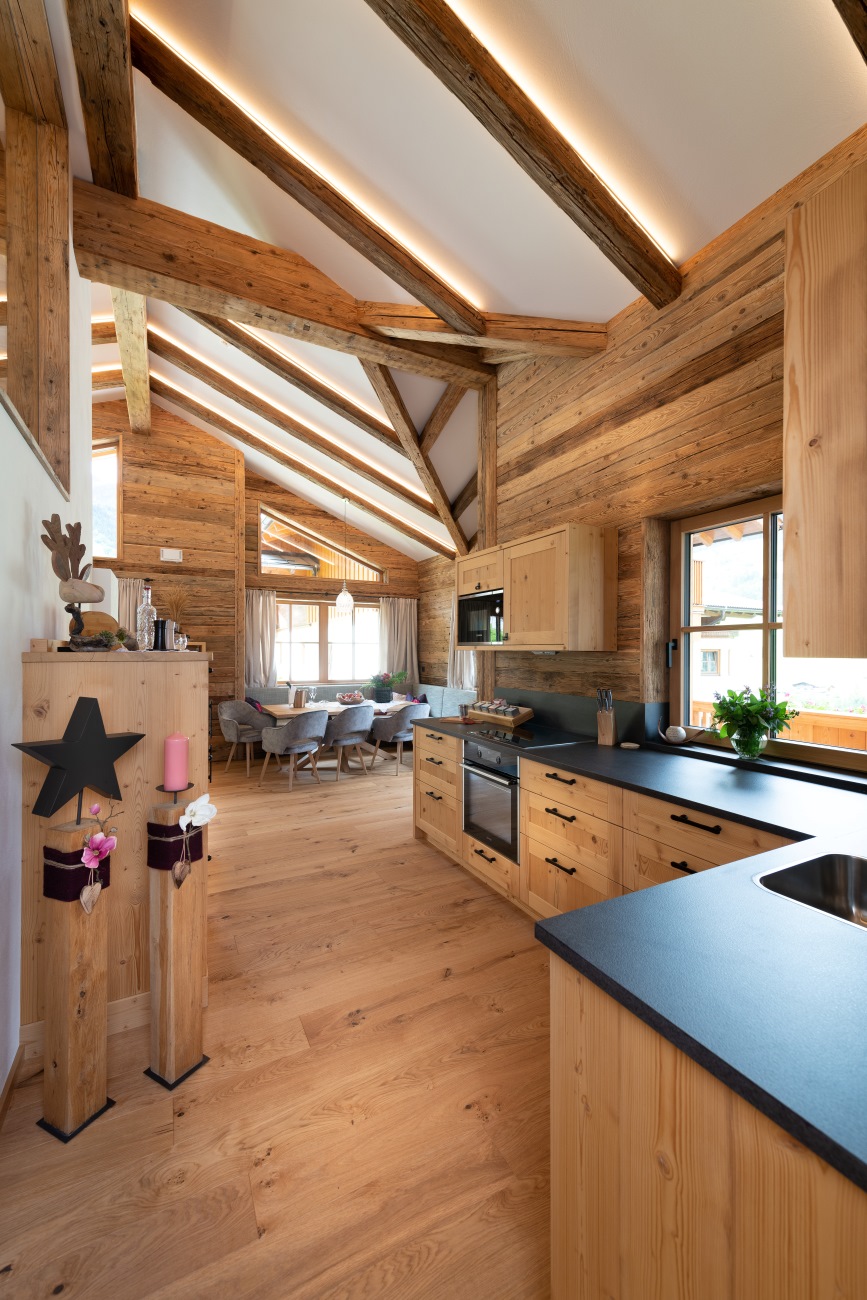 Moderne Holzküche mit Essbereich, Holzdecke und hellen Fenstern
