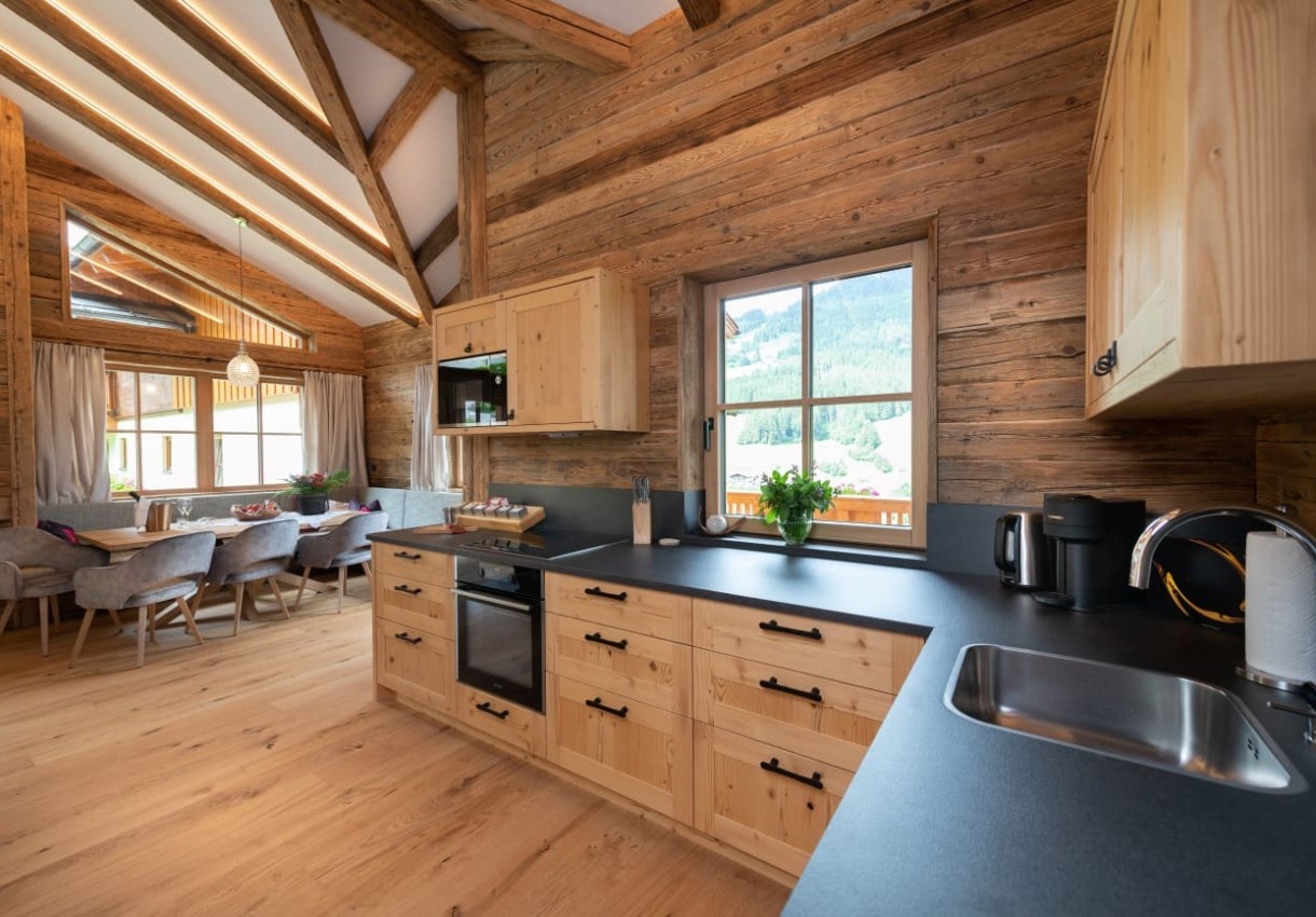 Moderne Holzküche mit Esstisch und Blick auf die Berge