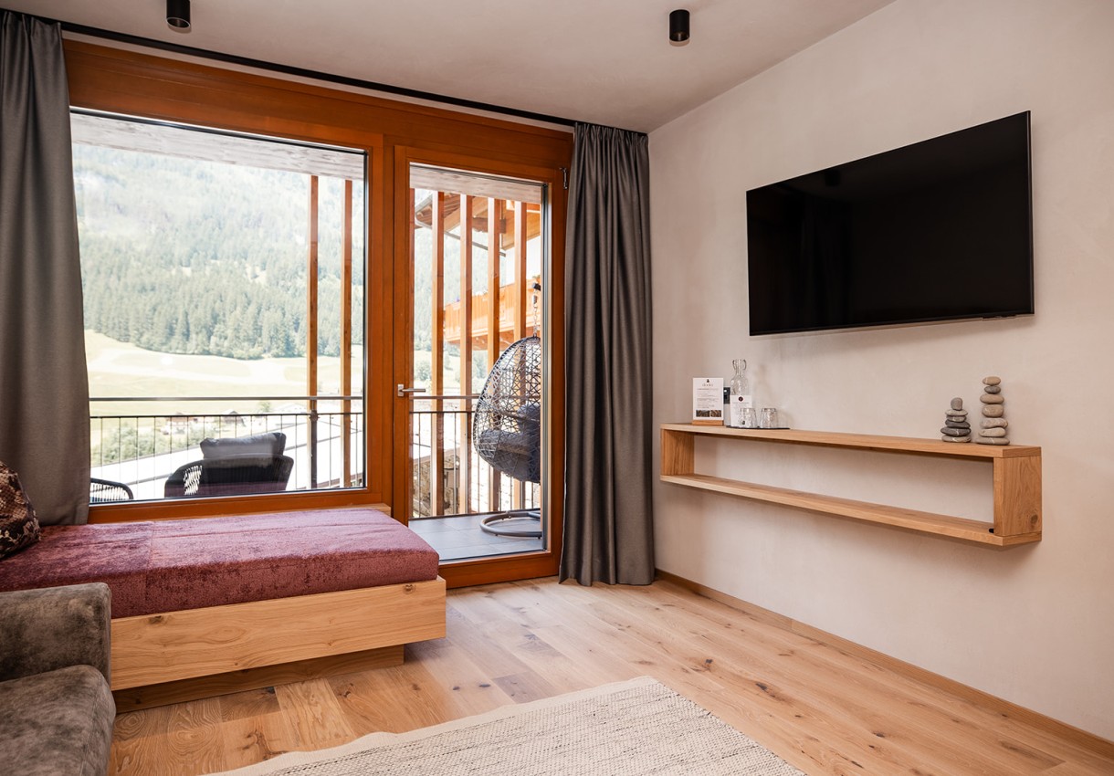 Modernes Wohnzimmer mit Holzboden, Sofa und großem Fenster mit Landschaftsblick