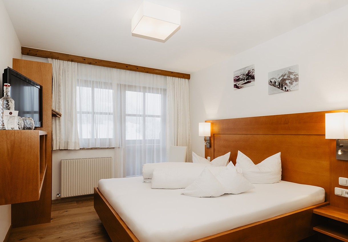 Ein modernes Hotelzimmer mit Holzverkleidung und einem großen Doppelbett