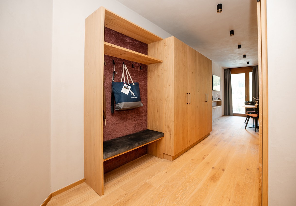 Ein moderner Flur mit Holzdekor, Garderobe und Tisch am Fenster